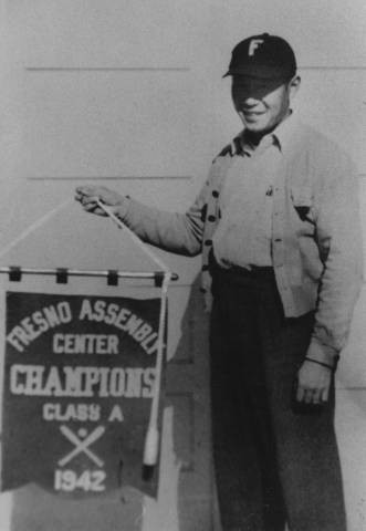 Herb Kurima holding 1942 baseball championship banner