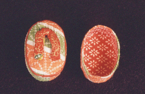 Orange and green container shaped in likeness of sandal