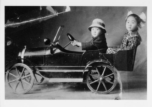 Young boy and girl in toy car