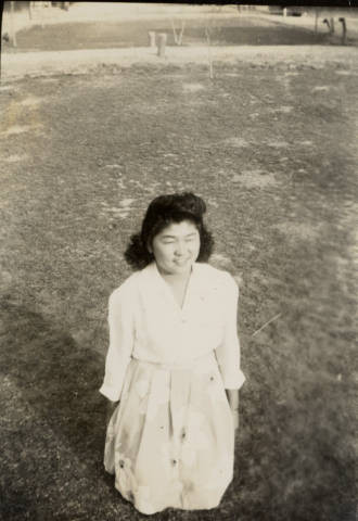 Kiyoko Imoto sitting on grass at Poston II