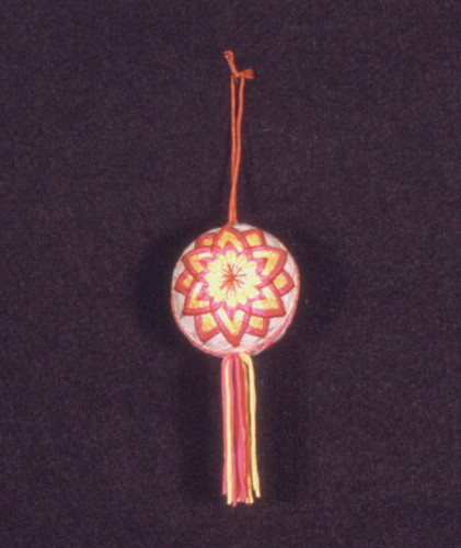 Temari thread ball with gold and pink flower pattern