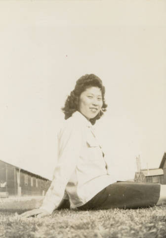 Jane Hayashi sitting on grass at Poston II Relocation Center