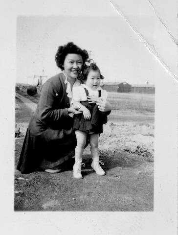 Women with child outside barracks at Tule Lake Relocation Center [?]