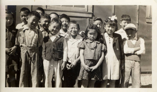 Group of Charlotte Craft's students at Tule Lake Relocation Center school in front of classroom