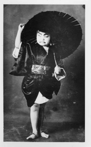 Naoko Takeuchi dressed as male character and holding an umbrella in a Kabuki play