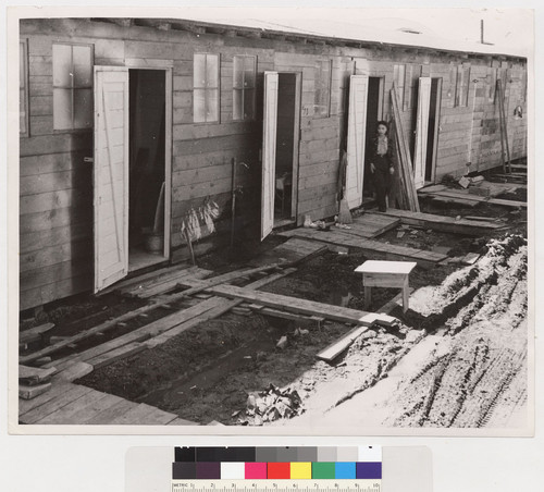 C-324. 4/29/42. Tanforan Assembly Center, San Bruno, California. Barracks for family living quarters. Each door enters into a family unit of two small rooms (remodeled horse-stalls.) Tanforan Assembly Center was opened two days before the photograph was made. On the first day there had been a heavy rain. When a family has arrived here the first step of evacuation is completed