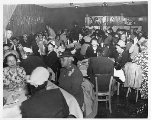 Women seated at white cloth covered tables in main dining area of Slim Jenkins Bar and Restaurant Oakland, California