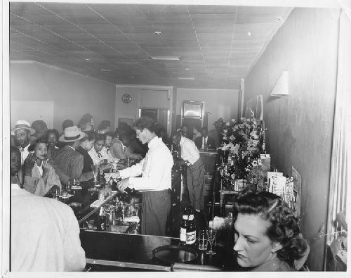 Patrons seated and standing at bar at Slim Jenkins nightclub Oakland, California