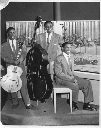 Musicians Bob Lewis (bass), Norvell Randell (piano), Eric Miller (guitar)on stage at Slim Jenkins Bar and Restaurant Oakland, California