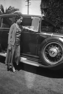 Young woman standing next to automobile