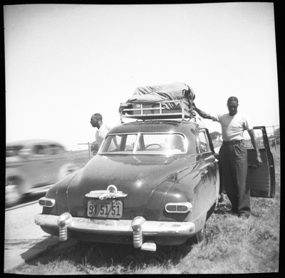 Two men getting out of car parked along highway