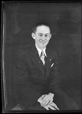 Portrait of a man in suit sitting with arms crossed