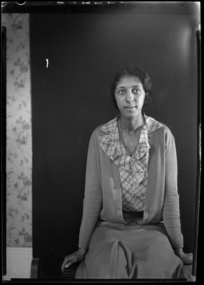 Portrait of woman in plaid blouse sitting on bench