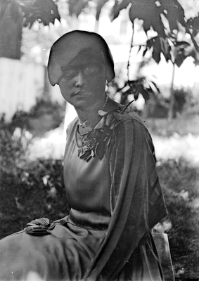 Portrait of a young woman sitting on bench in yard