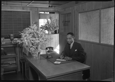 U.S. Griggs, Golden State Insurance Company district manager, sitting at his desk