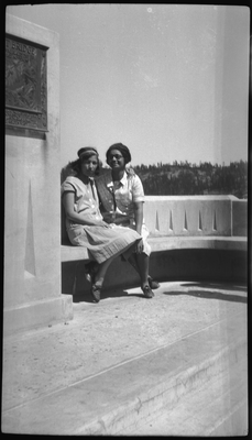 Two young women sitting on concrete bench on Donner Summit Bridge