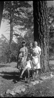 Pearl Hinds Roberts and group of women and children standing next to pine tree