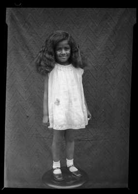 Portrait of girl standing on stool