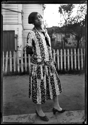 Portrait of woman standing next to picket fence