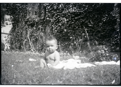 Baby sitting on blanket in yard