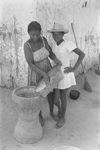 Woman pouring corn into mortar, San Basilio del Palenque, ca. 1978
