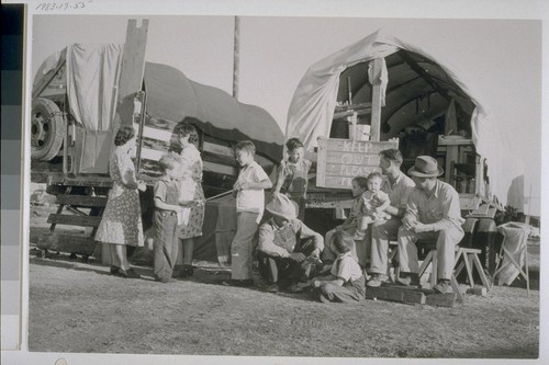 Both these families are now forced to live and eat and sleep in and under the "covered wagon" truck at the right, because the other truck is used as a "pest house" for two members of the family who are ill. "Our friends back home write and ask us about jobs in the shipyards," they say. "We write back and tell em wages are high, but we wouldn't have come if we'd known we couldn't find houses to live in."