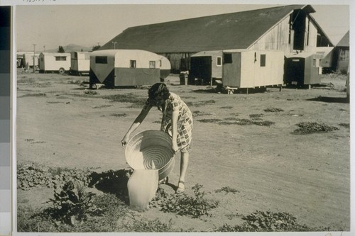 There are neither sewers nor septic tanks in this trailer camp which accomodates [sic] several hundred people. Waste water is thrown out "just anywhere." Autumn rains will bring deep mud to this old barnyard