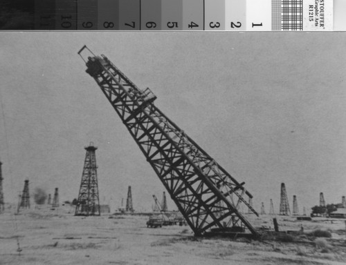 Tearing down wooden oil derrick