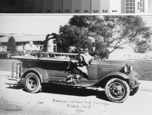 Charles Gann riding in fire engine