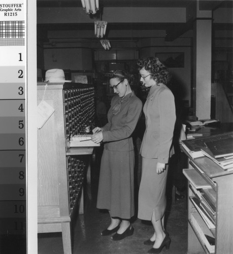 Librarian using card catalog