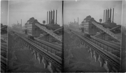 From Crane looking N.E. to Power house at right and Blast furnace at left. Coal and Iron Ore in line in foreground, Ford Motor Plant, Detroit, Mich