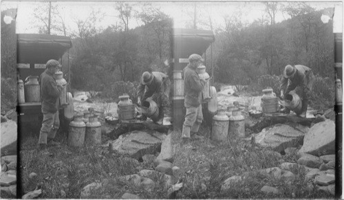 Unloading cans at destination and pouring part of water out so that brook water may be added. Wayne Co., Penna