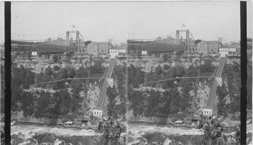 Dixon sitting on chair on rope over Niagara River. New York