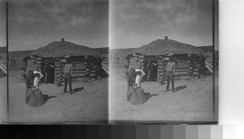 A Navaho and his family in front of a Hogan near Ft. Defiance, Ariz