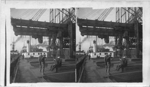 Unloading an ore steamer, lowering a 5-ton electric clam into the hold, Cleveland, Ohio