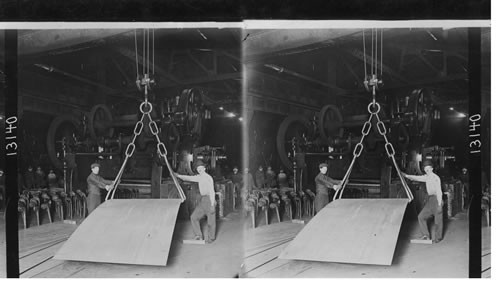 Lifting huge sheet of steel in steel mill. Steel Plate - 6x25 and huge shear for trimming. Homestead, Penna