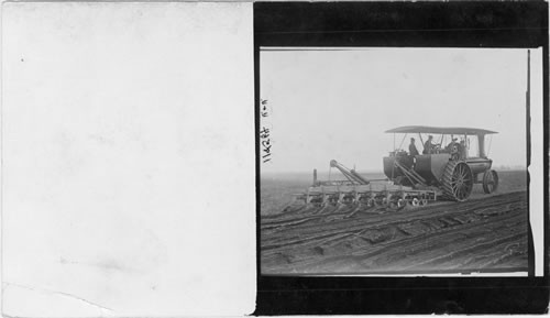 Plowing with a tractor and several plows, Long Island, N.Y