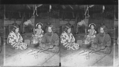 Interior of an Ainu home, showing owner and family, Yezo