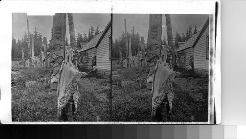 Alaska. A native in fantastic costume and village with totume [totem] poles