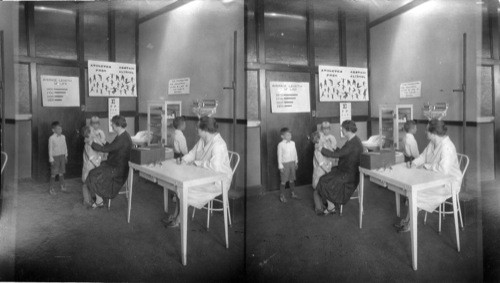 School doctor examining girl's throat, Chicago Ill