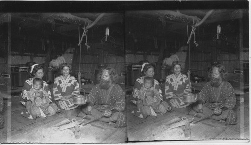 Interior of an Ainu home, showing owner and family, Yezo