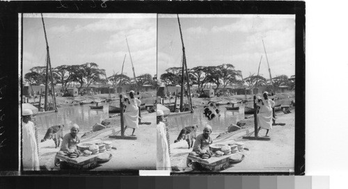 A vendor of bread and pastries at the Ragheb Pacha Bridge, Mahmoudieh Canal, Alexandria, Egypt. no. 752-1200 world tour. December 1932, service