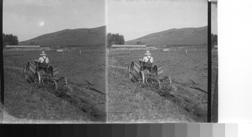 Breaking prairie sod with a tractor in the foothills of Alberta, Canada