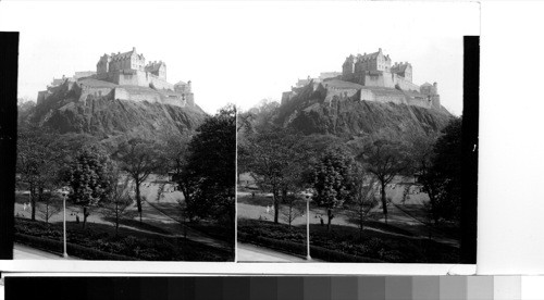 Great Britain, Scotland, Edinburgh: Edinburgh castle atop Castle Rock with Princes Gardens in the foreground. The rock at the western end of the old town was undoubtedly the site of an early settlement in the days of the Pictish kings and in the 7th century a military post was established here by Edwin, first Christian King of Northumbria. The great rock rises more than 400 feet above sea level and was once surrounding by a low-lying marshy stretch known an old nor' loch. in 1816 this was drained and from it has evolved the lovely public gardens (Princes Gardens) flanked by Princes Street