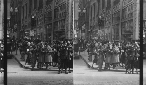 Officer restraining pedestrian crowds, Saturday noon rush hours, Kansas City