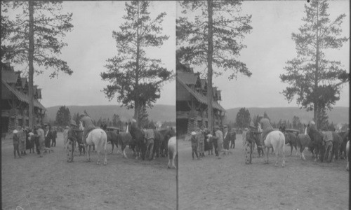 Saddle horses in the front of Old Faithful Inn, with party getting ready for trip