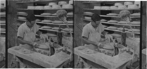 "Jigger" machine operated by individual electric motor, its speed controlled by a lever operated by worker's leg. Worker removing surplus clay. "Lenox Inc.", makers of fine chinaware Trenton, N.J