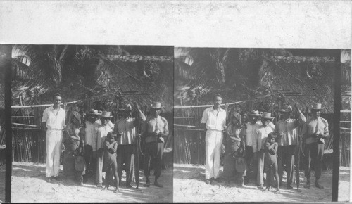 Myself and Group of San Blas Indians In Front of Native Houses. [Incorrect. They live on the San Blas Islands but are called Cuna Indians]