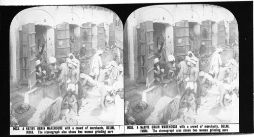 Inscribed in recto: 9033. A NATIVE GRAIN WAREHOUSE with a crowd of merchants, DELHI, INDIA. The stereograph also shows two women grinding corn