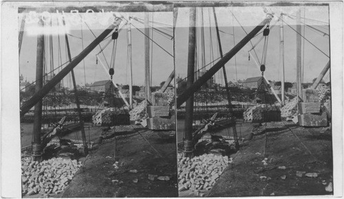 Granite Belgium blocks paving stones being placed on sailing ships for transportation. Cape Ann